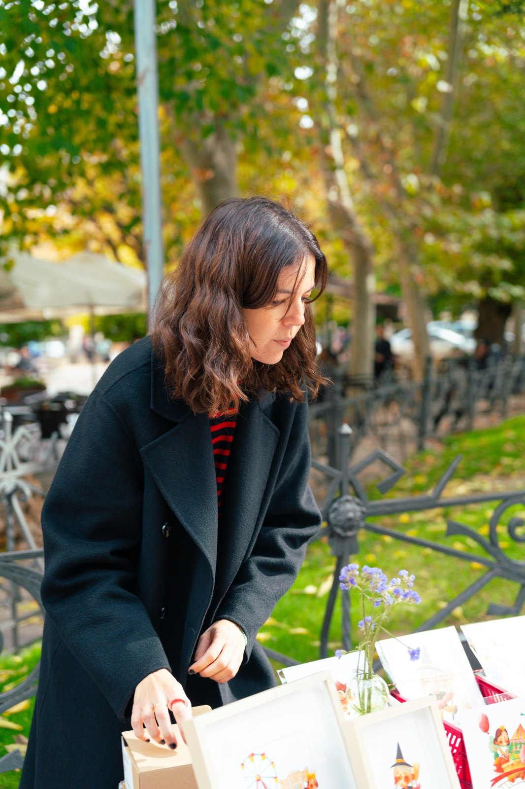 Cristina preparando una mesa con ilustraciones y productos de EME Taller Creativo
